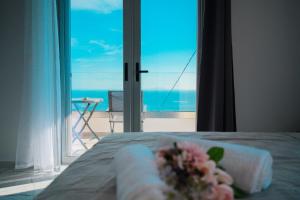 a room with a bed with a view of the ocean at Ionian Pearl in Dhërmi