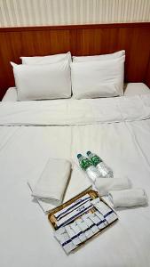 a white bed with towels and a bottle of water on it at Ying Lun Hotel in Taitung City