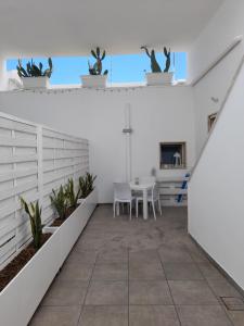 Cette chambre est dotée de murs blancs, d'une table et de chaises. dans l'établissement SALENTO d' aMARE, à Torre Lapillo