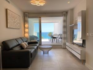 salon z czarną kanapą i widokiem na ocean w obiekcie Deluxe sea view apartment with a swimming pool w mieście Benalmádena