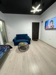 ein Wohnzimmer mit einem blauen Sofa und einem Tisch in der Unterkunft First line sea in Năvodari + 7 Fotos