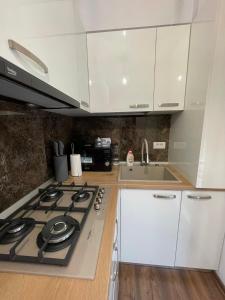 eine Küche mit weißen Schränken und einem Herd mit Backofen in der Unterkunft First line sea in Năvodari