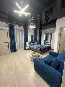 ein Wohnzimmer mit einer blauen Couch und einem Bett in der Unterkunft First line sea in Năvodari