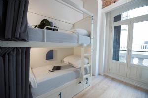 a room with two bunk beds and a window at room00 Gran Vía Hostel in Madrid