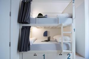 two bunk beds in a room with a desk at room00 Gran Vía Hostel in Madrid