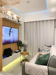 ein Wohnzimmer mit einem Sofa und einem Flachbild-TV in der Unterkunft Spring Residences 1 Bedroom Deluxe Near Airport in Manila