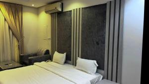 Habitación de hotel con 2 camas y ventana en اجواء المساء للوحدات السكنيه المفروشه, en Riad