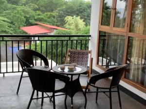 a patio with a table and chairs on a balcony at Aambal Villa Homestay in Meenangadi