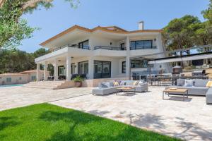 a large white house with couches and a patio at SA GUARDA in Llafranc