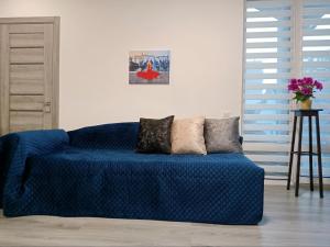 um sofá azul com duas almofadas num quarto em Family Apartments Dorobok em Lviv