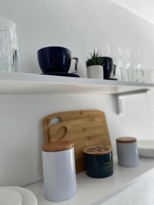 a shelf with bowls and cups on it at Apartament in regim hotelier Queen Medias in Mediaş