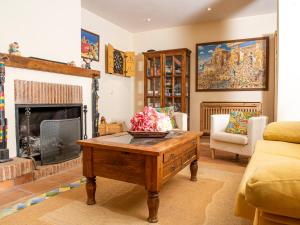 a living room with a fireplace and a wooden coffee table at Apartamento Rústico en Ojén in Ojén