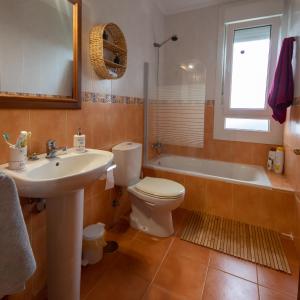 a bathroom with a sink and a toilet and a tub at El Gato Gordo - bike & surf house in Cudillero