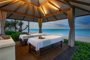 潘切的住宿－Radisson Resort Phan Thiet，海滩凉亭内的2张餐桌