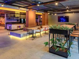 a bar with tables and chairs and plants at Ibis Balneario Camboriu in Balneário Camboriú