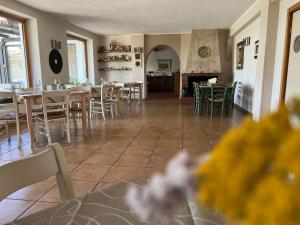 una sala da pranzo e una cucina con tavoli e sedie di Masseria Brica Rossa a Thurio