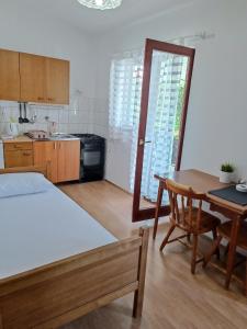 a kitchen with a table and a dining room at Apartments Branka- 4 apartments in house- 1 apartment has jacuzzi in Vir