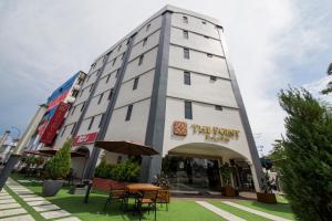 un grande edificio bianco con tavoli e sedie di fronte di The Point Boutique Hotel a Johor Bahru