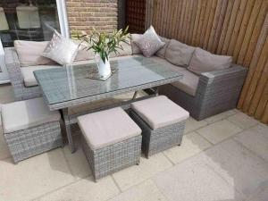 a patio table and chairs with a couch and a table at Modern 4 bedroom house in Weymouth in Weymouth