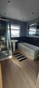 a bathroom with a bath tub and a sink at Modern 4 bedroom house in Weymouth Sunny Corner in Weymouth