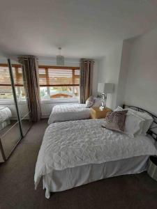 a bedroom with two beds and a large window at Modern 4 bedroom house in Weymouth Sunny Corner in Weymouth +36 photos