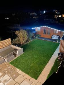 a backyard at night with a green lawn at Modern 4 bedroom house in Weymouth in Weymouth