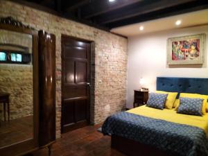 a bedroom with a bed and a brick wall at Villa Burión in Llanera +20 photos