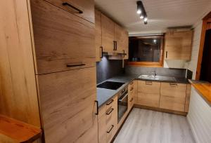 a kitchen with wooden cabinets and a sink at Séjour cosy au Chamily in Somme-Leuze +17 photos