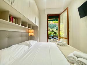 Un dormitorio blanco con una cama con toallas. en CasaViva - Trilo with patio in Santa Margherita L., en Santa Margherita Ligure