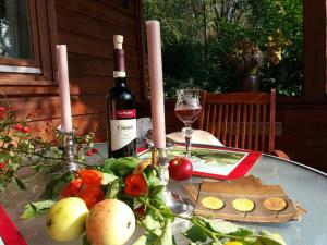 una mesa con una botella de vino y un plato de comida en Romantisches Blockhaus an der Märchenstraße!, en Reinhardshagen