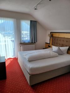 a bedroom with a large bed and a large window at Wittelsbacher Hof in Oberstdorf