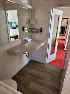 ein Bad mit einem Waschbecken und einem Spiegel in der Unterkunft Wittelsbacher Hof in Oberstdorf