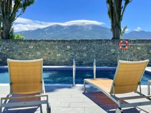 duas cadeiras e uma mesa ao lado de uma piscina em Hotel Fontanals Golf em Soriguerola