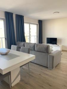 uma sala de estar com um sofá e uma mesa em Elite Residense a 150 mts Praia da Rocha em Portimão