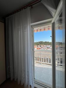 a large window with a view of a balcony at Apartments and Rooms Jasna in Hvar