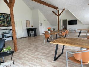 una grande stanza con tavoli e sedie in legno di Luksuslejlighed til 8 personer i hjertet af Sønderjylland a Branderup