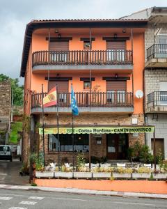 un edificio con due bandiere davanti di Hotel Rural Cristania a Caminomorisco