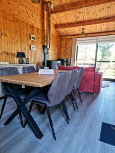 a dining room with a large wooden table and chairs at Séjour cosy au Chamily in Somme-Leuze