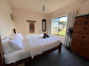 Un dormitorio con una cama con un osito de peluche. en Twelve Apostles Ocean View, en Princetown