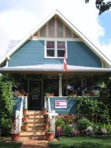 a blue house with a flag in front of it at Phoenix House B&B in Stettler