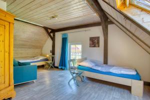 een kamer met 2 bedden en een bank in een kamer bij Tom olen Stien - Heidjer Ferien in Oldendorf