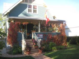 a house with a flag on the front of it at Phoenix House B&B in Stettler