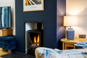 a living room with a fireplace with a blue wall at Tall Ships, Charlestown - two ticks from the harbour in Charlestown