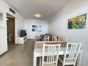a dining room and living room with a table and chairs at Sea view pool apartment Mojon hills in Isla Plana