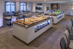 uma linha de buffet com vários produtos de pastelaria em exposição em Golden Acqua Salou em Salou