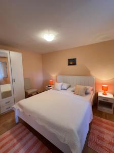 a bedroom with a large white bed with two lamps at Apartments and Rooms Jasna in Hvar