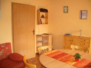 a dining room with a table and chairs and a kitchen at Ferienwohnung am Busterbach in Seebach