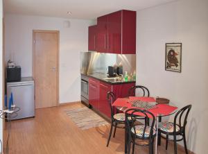 a kitchen with red cabinets and a red table and chairs at Chez Pio in Murten