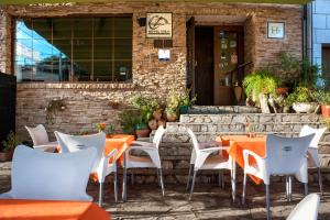 an outdoor restaurant with orange tables and white chairs at Hotel Rural Cristania in Caminomorisco