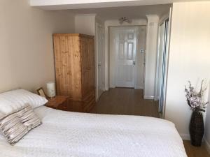 a bedroom with a white bed and a hallway at Beautiful 3-Bed Apartment in Gourock in Gourock